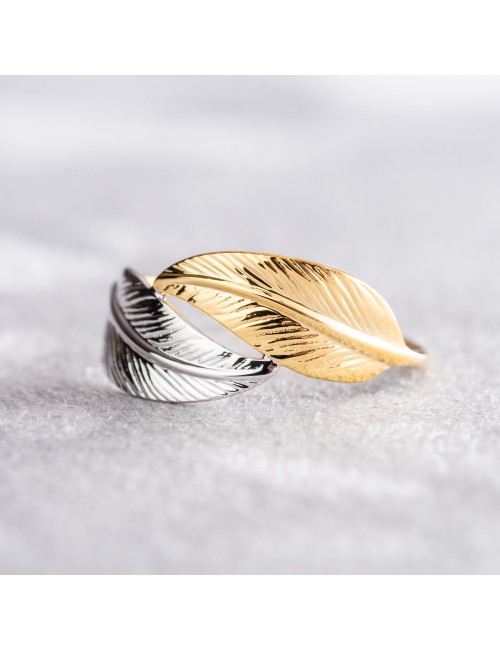 Laissez-vous emporter par la légèreté et la délicatesse de cette bague ornée de deux plumes en Or jaune et blanc 9 carats