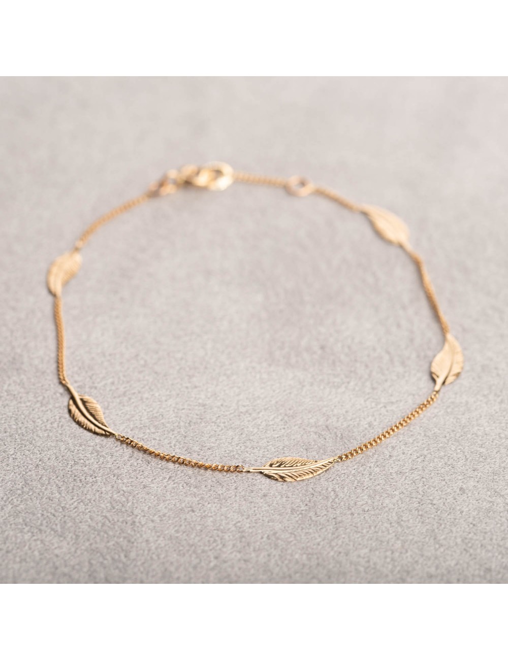 Bracelet femme orné de cinq plumes en or 18 carats.